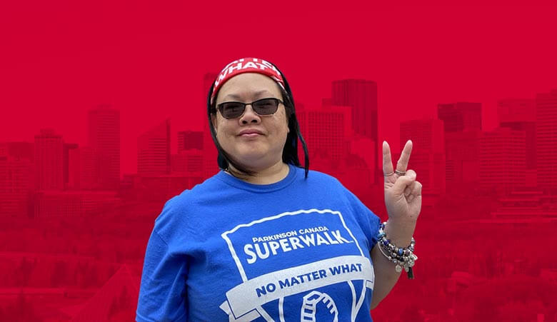 Image of Betty Chan in a SuperWalk t-shirt showing a peace sign.